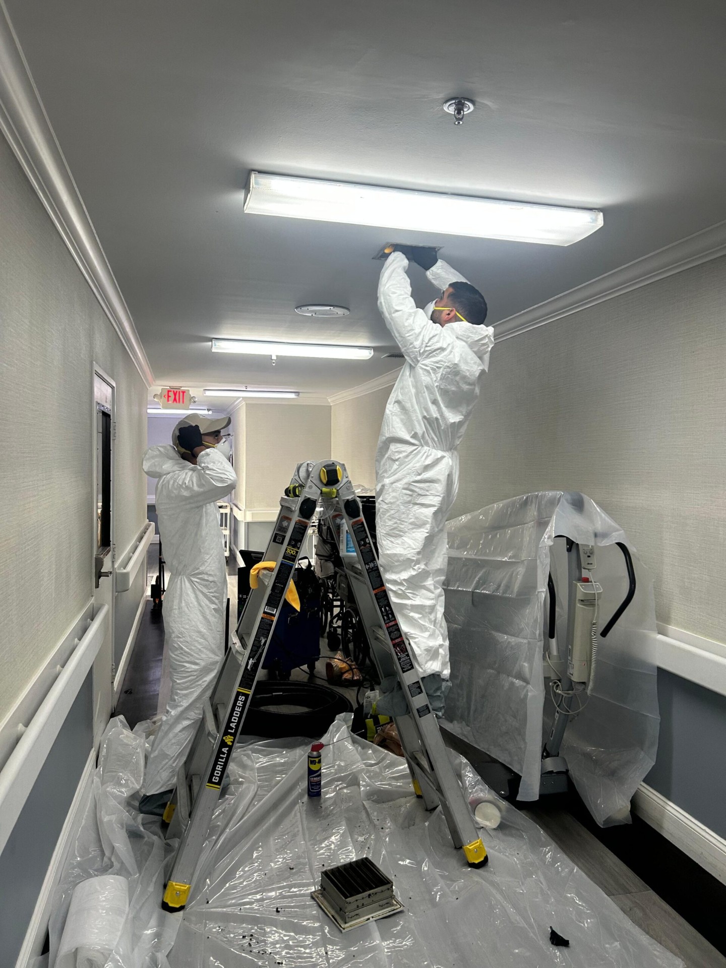 Certified Air Quality Pros USA technicians performing professional air duct cleaning in a commercial building